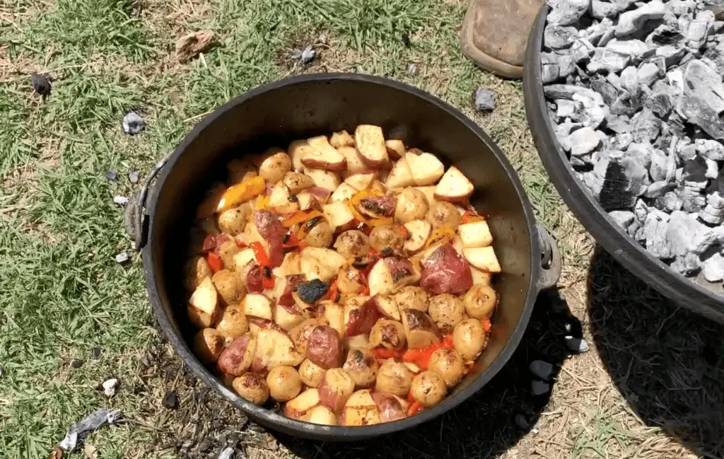 Potatoes and peppers cooking in a Dutch oven.