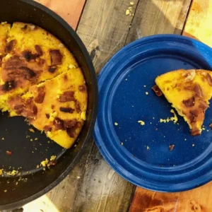 A plate of cornbread with bacon bits.