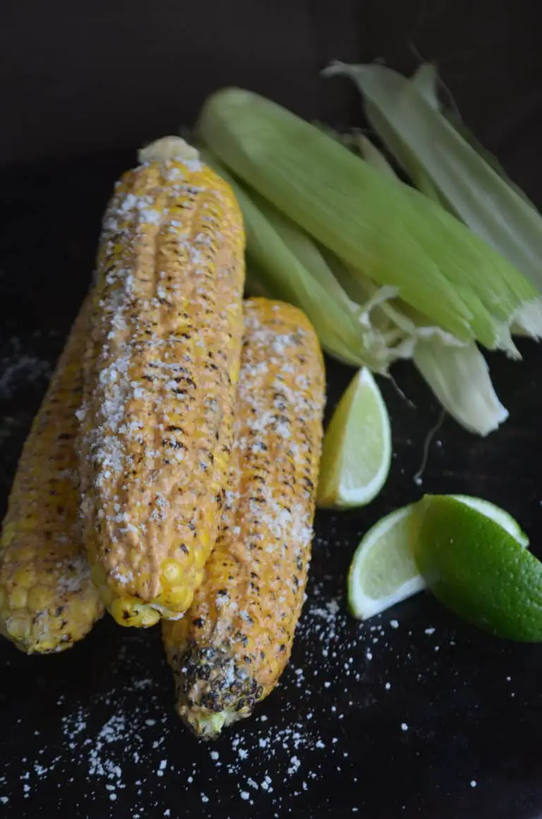 Grilled corn on the cob with lime wedges.