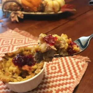 Forkful of stuffing with cranberry sauce.