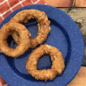 Three crispy onion rings on blue plate.