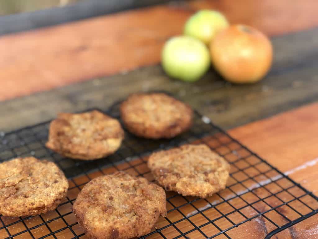 Five fried patties on a wire rack.