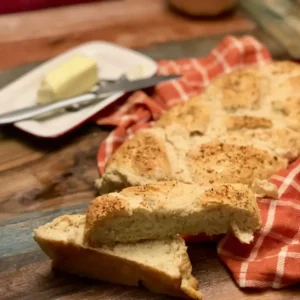 Freshly baked braided bread on red cloth.