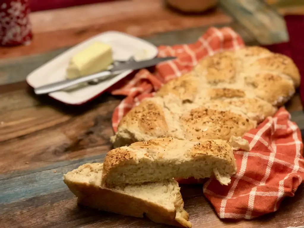 Freshly baked braided bread on red cloth.