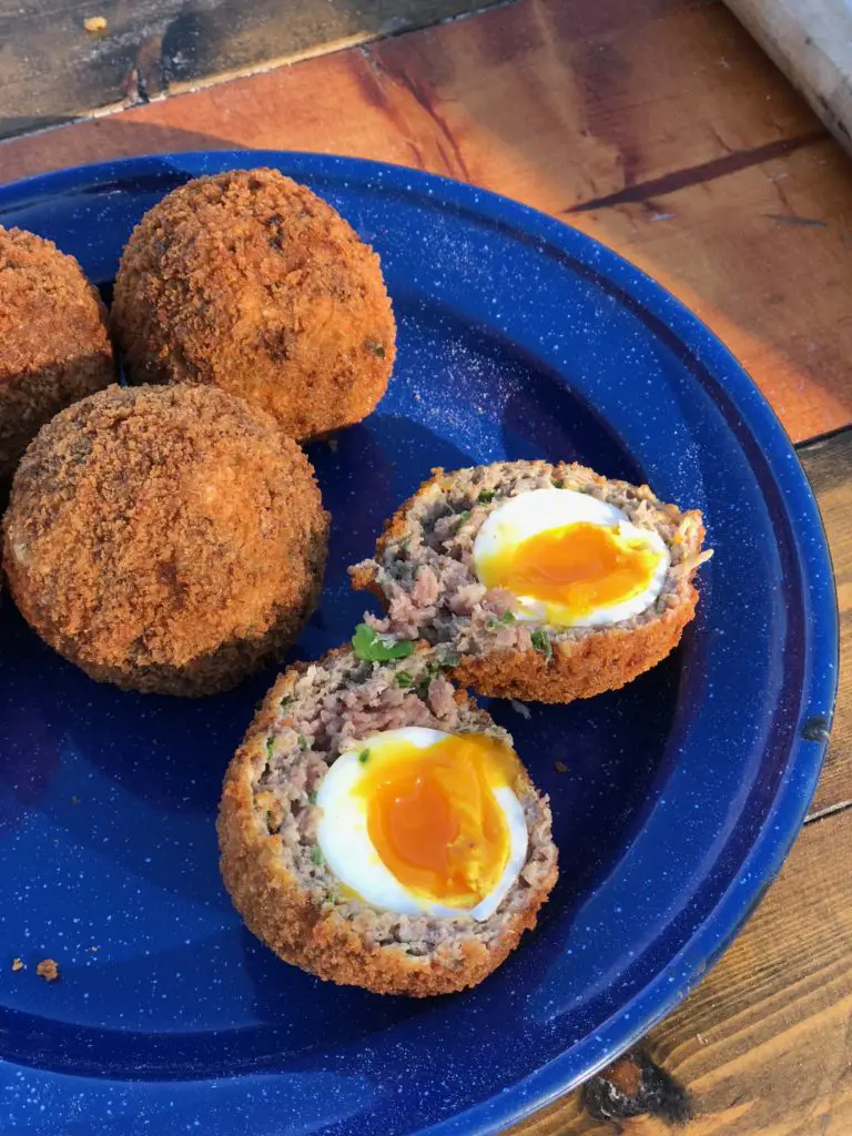 Scotch eggs on a blue plate.