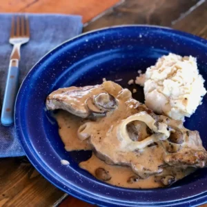 Steak with mushroom gravy and mashed potatoes.