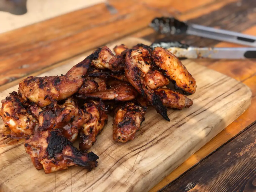 Grilled chicken wings on a cutting board.