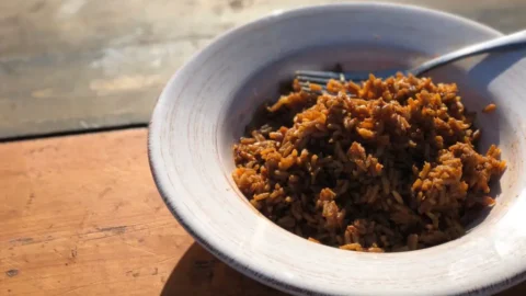 A white bowl of brown rice on a table.