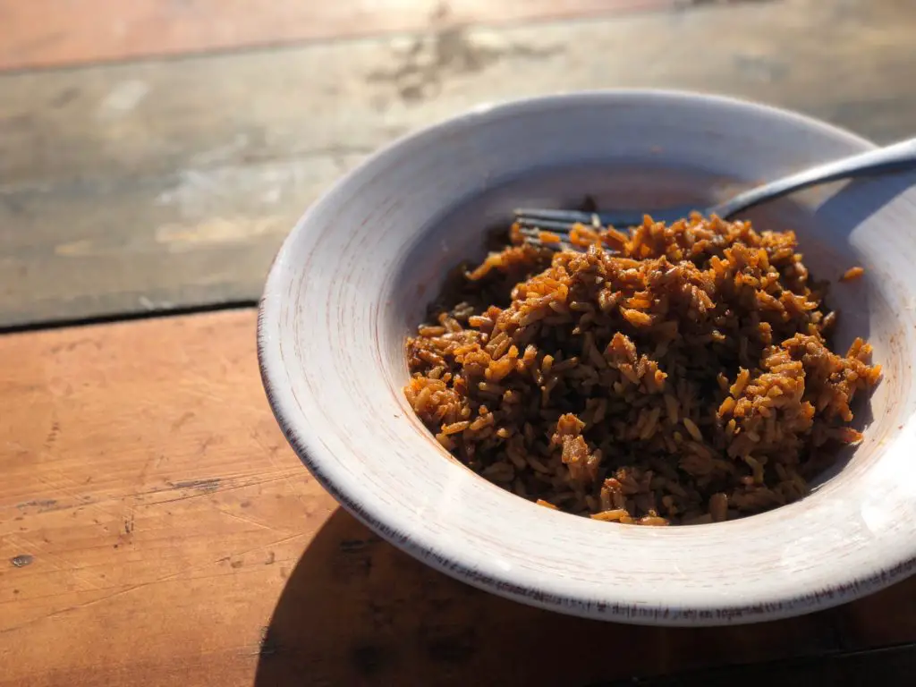 A white bowl of brown rice on a table.