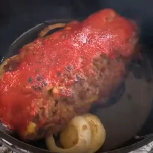 Meatloaf with tomato sauce in a pot.