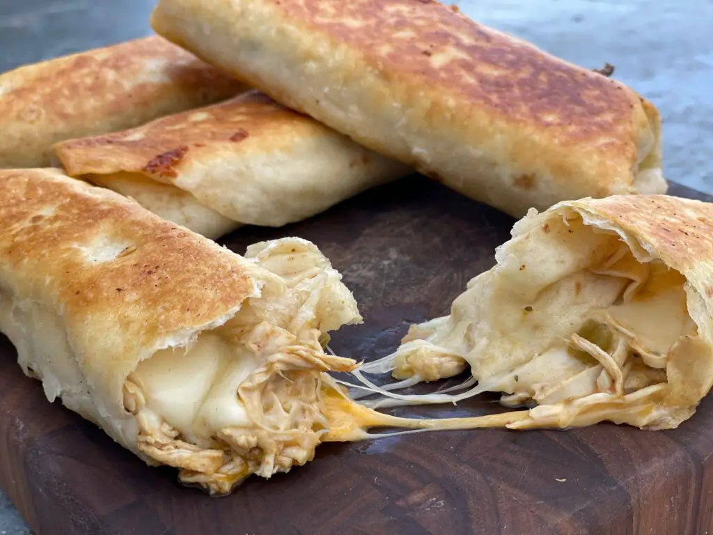 Crispy chicken and cheese quesadillas on wood board.