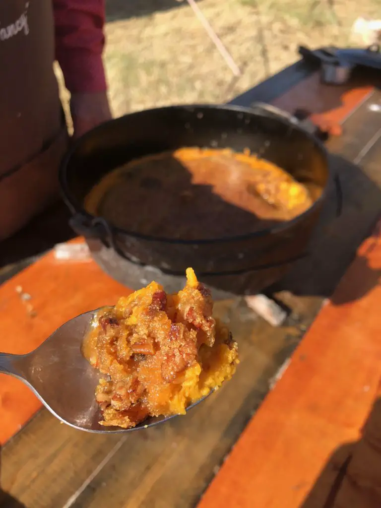 Sweet potato casserole with pecans on a spoon.