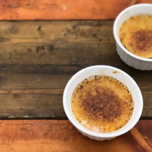 Two bowls of crme brle on wood.