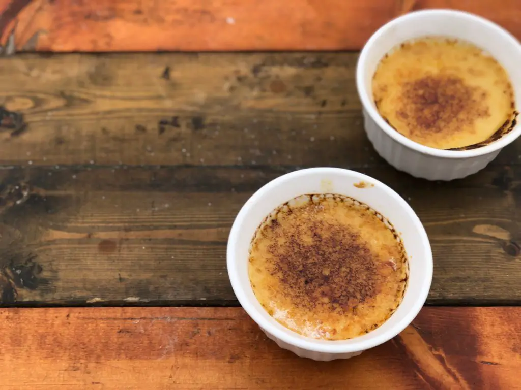 Two bowls of crme brle on wood.