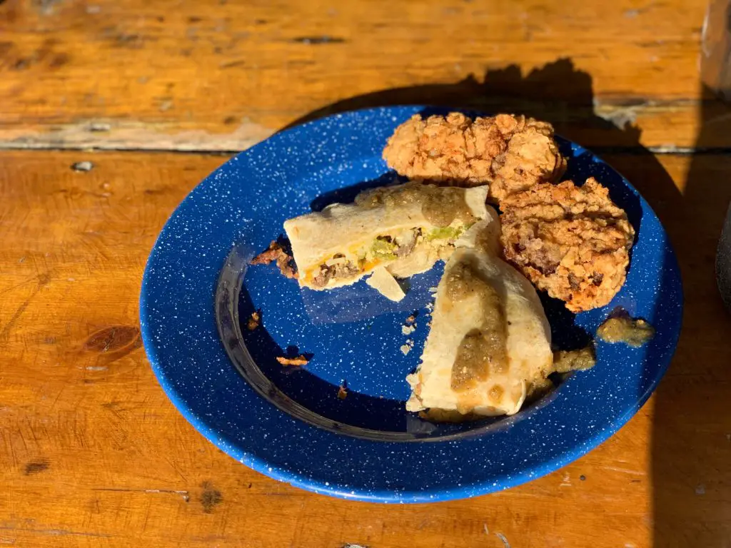 Fried chicken and tacos on blue plate.