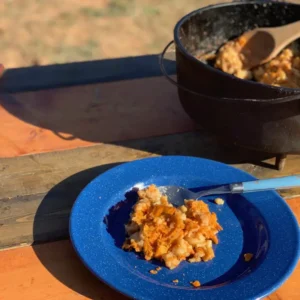 A blue plate with a serving of potato casserole.