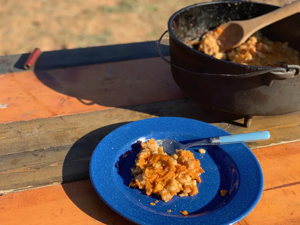 A blue plate with a serving of potato casserole.