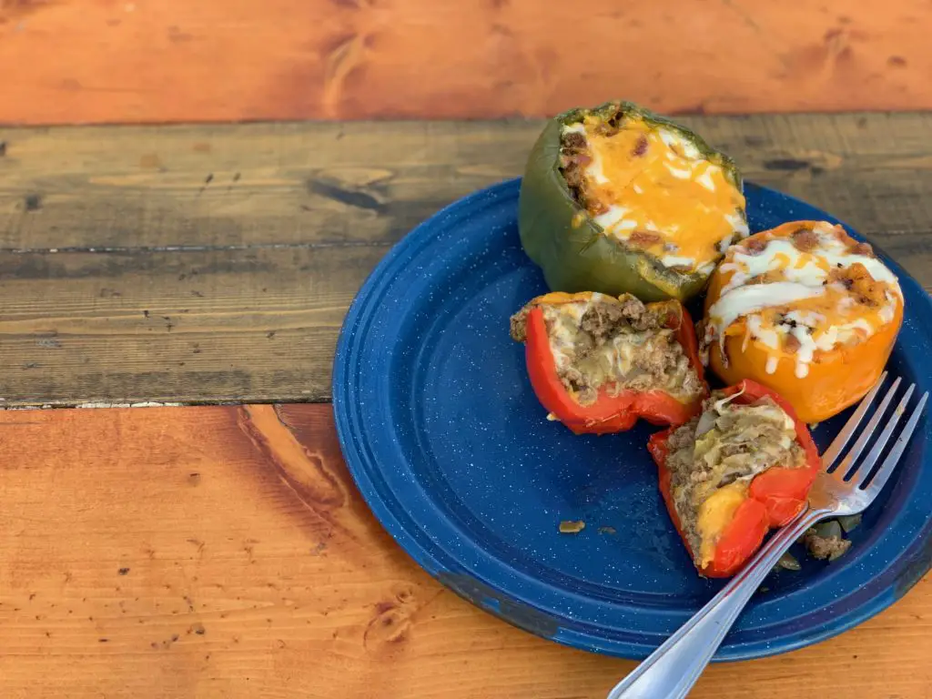 Stuffed peppers with cheese on a blue plate.