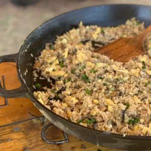 Fried rice with egg and green onions in a cast iron skillet.