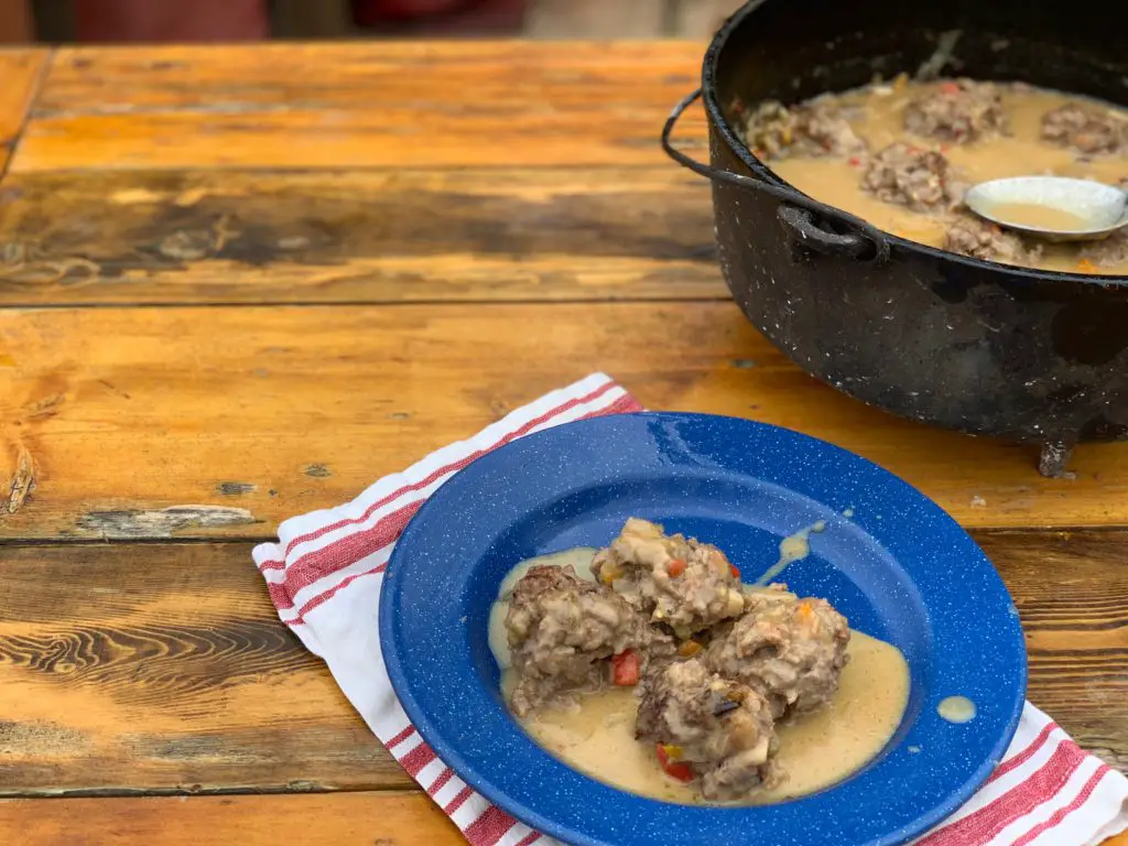 Meatballs in creamy sauce on a blue plate.