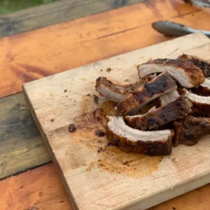 Grilled pork ribs on a wooden board.