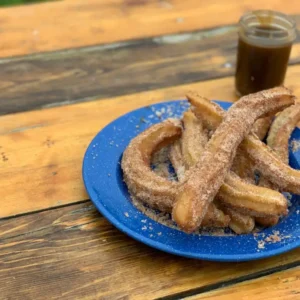 Cinnamon sugar churros on a blue plate.