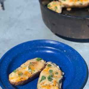 Two loaded baked potatoes on a blue plate.