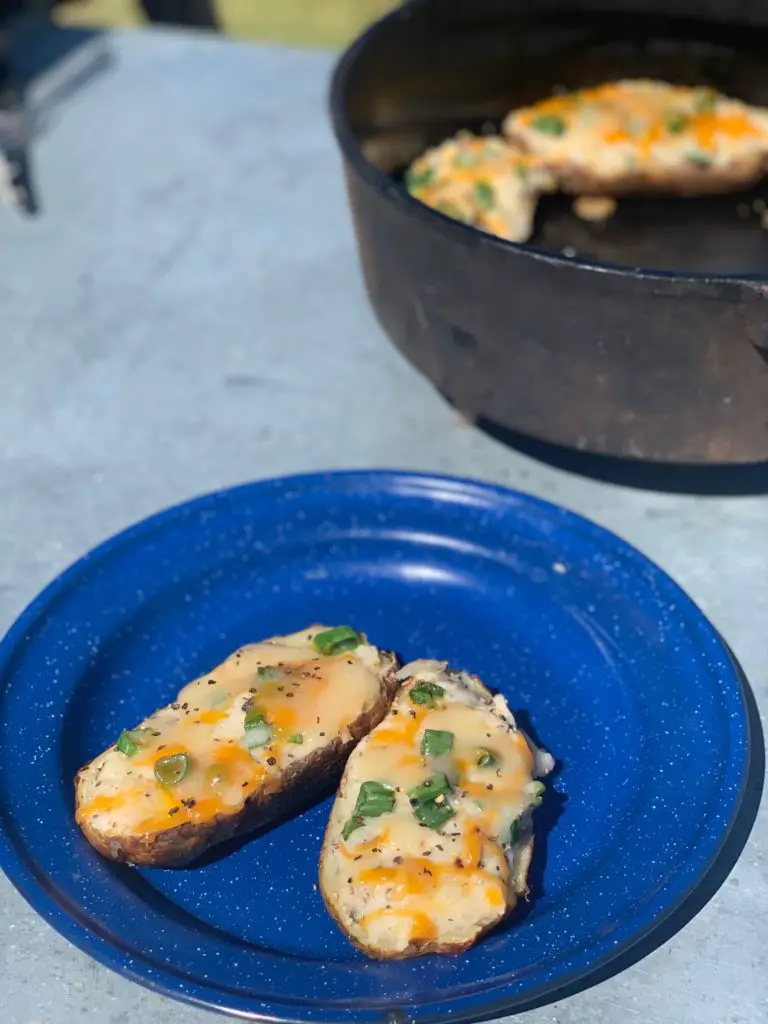 Two loaded baked potatoes on a blue plate.