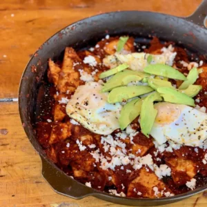 Chilaquiles with eggs, avocado, and cheese.