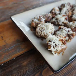 Cheese-stuffed mushrooms on a plate.