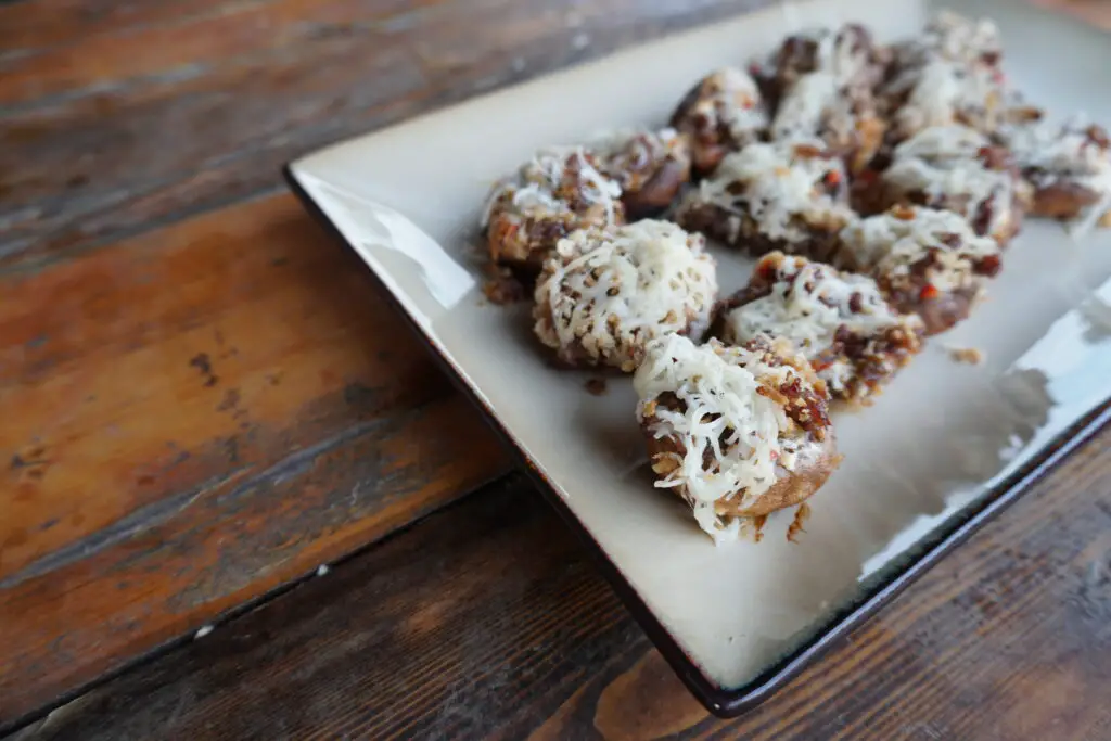 Cheese-stuffed mushrooms on a plate.