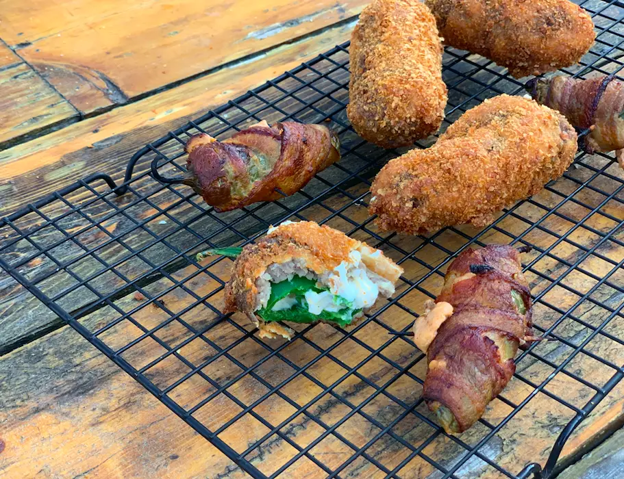 Fried jalapeno poppers on wire rack.