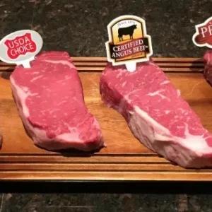 Four different cuts of beef on a cutting board.