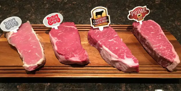 Four different cuts of beef on a cutting board.