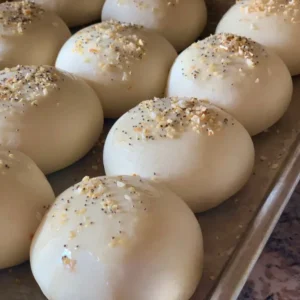 Baked rolls with poppy seeds on a tray.