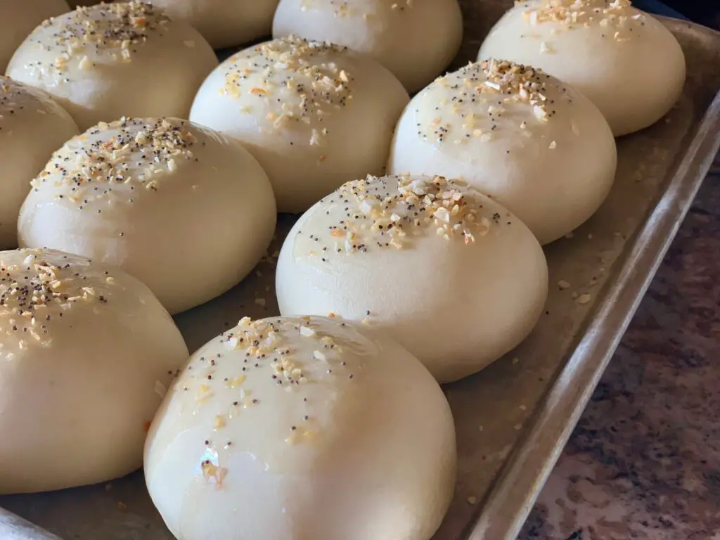 Baked rolls with poppy seeds on a tray.