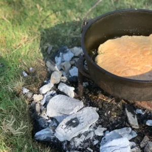 Dutch oven bread baking on coals.