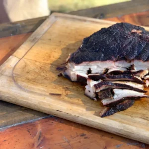 Smoked and sliced meat on a cutting board.