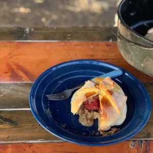 Half-eaten pastry on blue plate, wooden table.