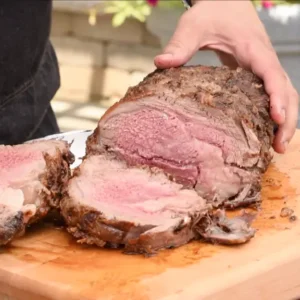 Sliced roasted beef on cutting board.