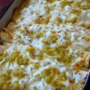 Cheesy green chile enchiladas in a baking dish.