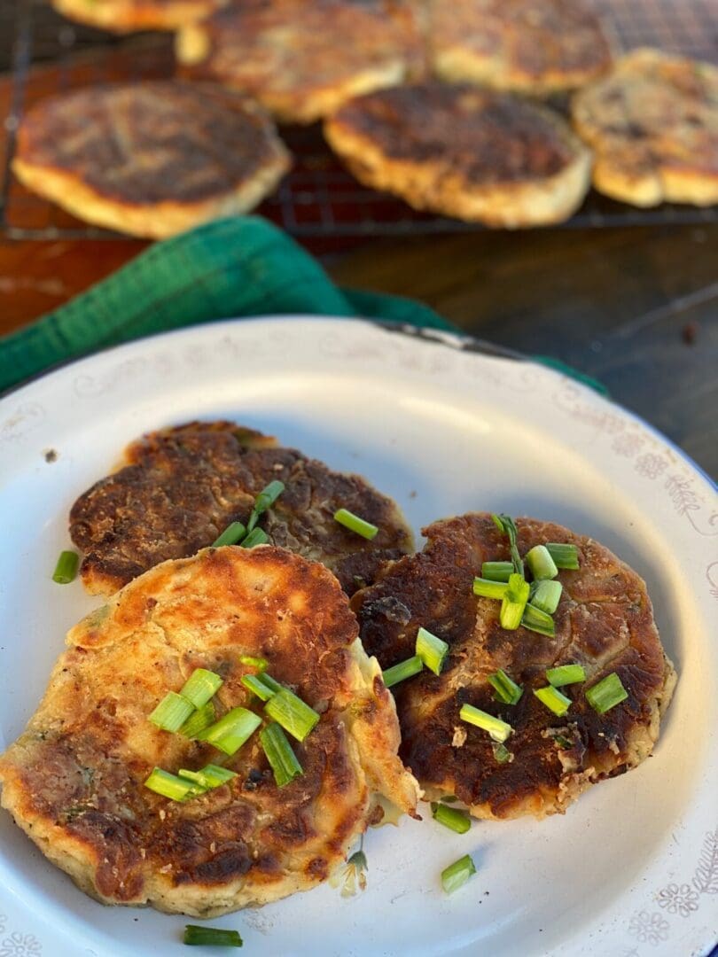 Three fried potato cakes with green onions.