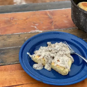 Biscuits and gravy on blue plate.