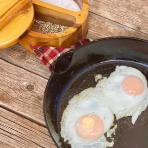 Two sunny side up eggs in a cast iron pan.