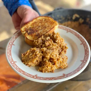 A plate of rice and meat with toast.