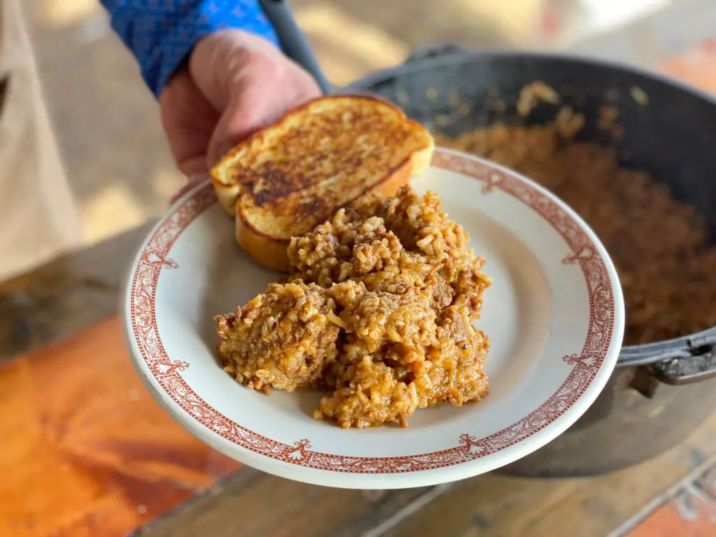 A plate of rice and meat with toast.