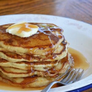 Buttery pancakes with syrup and a fork.