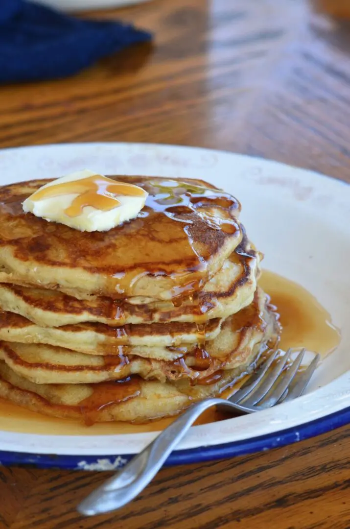 Buttery pancakes with syrup and a fork.