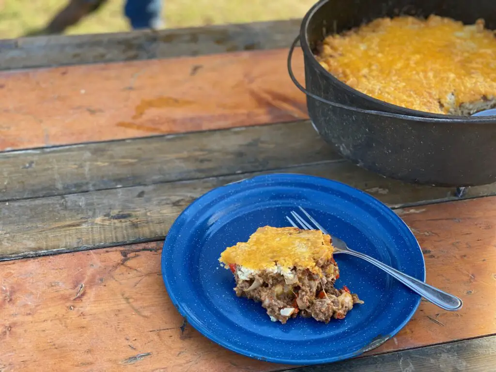 A slice of cheesy casserole on a blue plate.