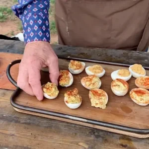 Deviled eggs on a wooden tray.